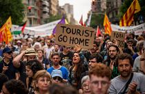 Göstericiler 19 Haziran 2024 tarihinde Barselona şehir merkezinde Formula 1 Barselona Taraftar Festivali'ne karşı sloganlar atarak yürüyor.