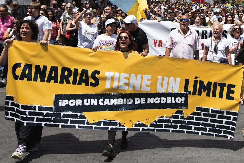 Pessoas marcham durante uma manifestação de massas contra o turismo que afecta a população local com habitações inacessíveis, entre outras coisas, em Santa Cruz de Tenerife