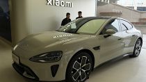 Visitors to the Xiaomi Automobile flagship store last month look at the Xiaomi SU7 electric car on display in Beijing