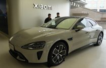 Visitors to the Xiaomi Automobile flagship store last month look at the Xiaomi SU7 electric car on display in Beijing