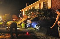 شرطة فريدريكسبيرغ وأفراد إدارة الإطفاء إلى جانب سيارة ارتطمت بمنزل