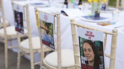 كرسي مع صور الأشخاص الذين اختطفهم أحد نشطاء حماس من إسرائيل في "طاولة الفصح الفارغة" التي تضم 133 كرسيًا