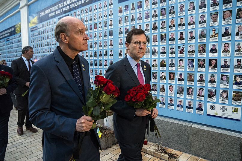 Members of US Congress place flowers at a memorial wall for Ukrainian soldiers killed during the war at Saint Michael cathedral in Kyiv