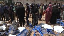 A woman looks among the bodies found in a mass grave in Khan Younis