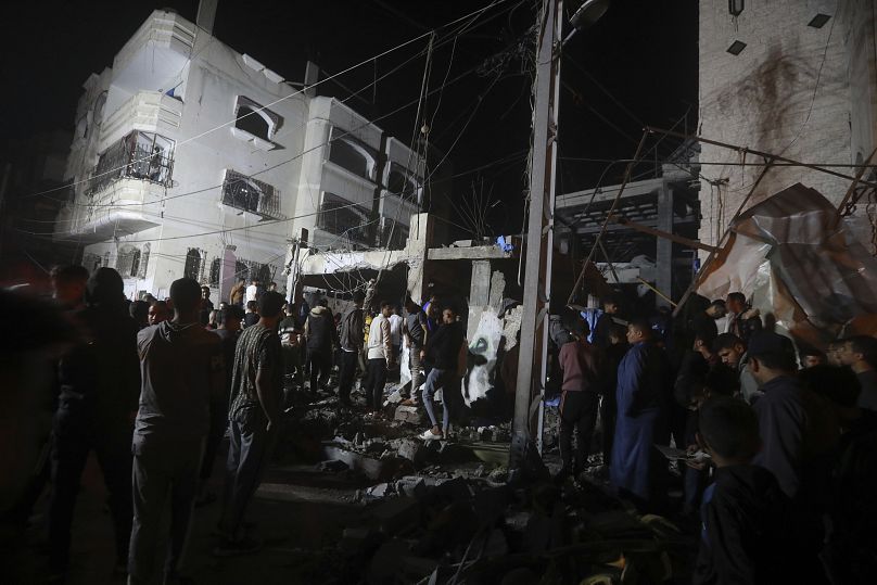 Palestinians inspect the rubble of destroyed buildings after an Israeli airstrike in Rafah refugee camp, southern Gaza