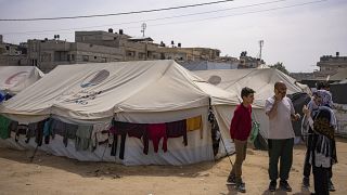 نازحون فلسطينيون أمام إحدى الخيم التي نصبت في مخيم في رفح