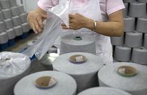 Egy munkás pamutfonalat csomagol egy textilgyártó üzemben, a kormány által külföldi újságíróknak szervezett utazás során, a kínai Hszincsiangban található Aksuban.