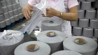Ein Arbeiter verpackt während einer von der Regierung organisierten Reise für ausländische Journalisten in Aksu in Chinas Xinjiang Baumwollgarnspulen in einer Textilfabrik.