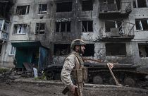 FILE - A Ukrainian soldier passes by a damaged apartment building in Chasiv Yar, the site of heavy battles with the Russian forces in the Donetsk region, Ukraine, Tuesday, May