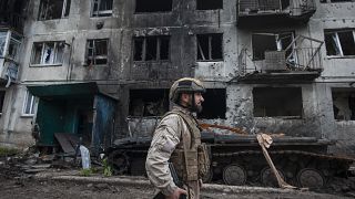 FILE - A Ukrainian soldier passes by a damaged apartment building in Chasiv Yar, the site of heavy battles with the Russian forces in the Donetsk region, Ukraine, Tuesday, May