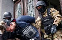 Members of the special police unit of Canton Sarajevo escort a person arrested in an operation codenamed "Black Tie" in Sarajevo, Bosnia, Monday, April 22, 2024