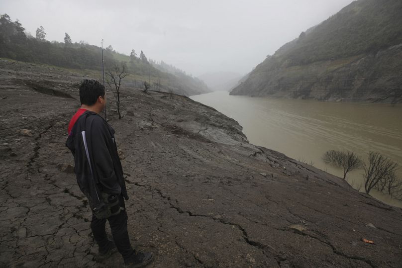 A man stands on the exposed banks of the Mazar reservoir, in the Azuay province of Ecuador.