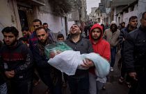محمد شومان يحمل جثمان ابنته ماسة، التي قتلت في قصف إسرائيلي على  رفح، جنوب قطاع غزة، الأربعاء، 17 يناير، 2024. 