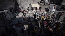 Uma família inspecciona a sua casa depois de esta ter sido atingida por um ataque aéreo israelita em Rafah, no sul de Gaza, a 4 de abril de 2024