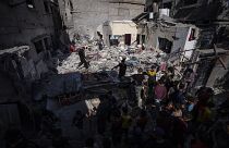 Una famiglia ispeziona la propria casa dopo che è stata colpita da un attacco aereo israeliano a Rafah, nel sud di Gaza (4 aprile 2024)