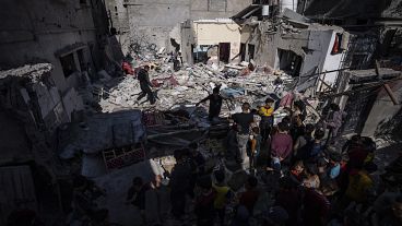 Uma família inspecciona a sua casa depois de esta ter sido atingida por um ataque aéreo israelita em Rafah, no sul de Gaza, a 4 de abril de 2024