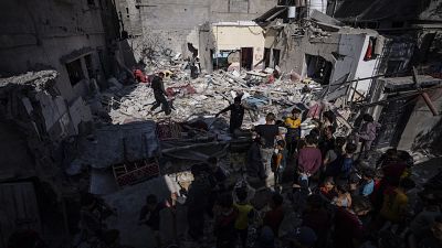 Egy család megvizsgálja a házukat, miután egy izraeli légitámadás érte a Gázai övezet déli részén fekvő Rafahban, 2024. április 4-én.