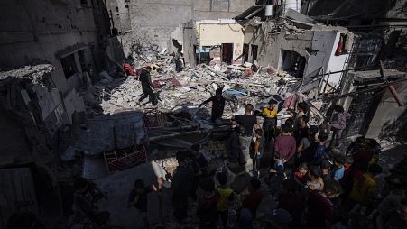 Egy család megvizsgálja a házukat, miután egy izraeli légitámadás érte a Gázai övezet déli részén fekvő Rafahban, 2024. április 4-én.
