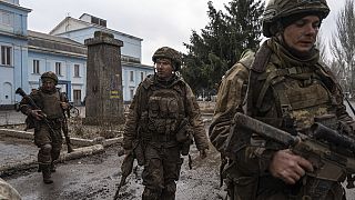 FILE PHOTO - Ukrainian servicemen who recently returned from the trenches of Bakhmut walk on a street in Chasiv Yar, Ukraine, Wednesday, March 8, 2023.