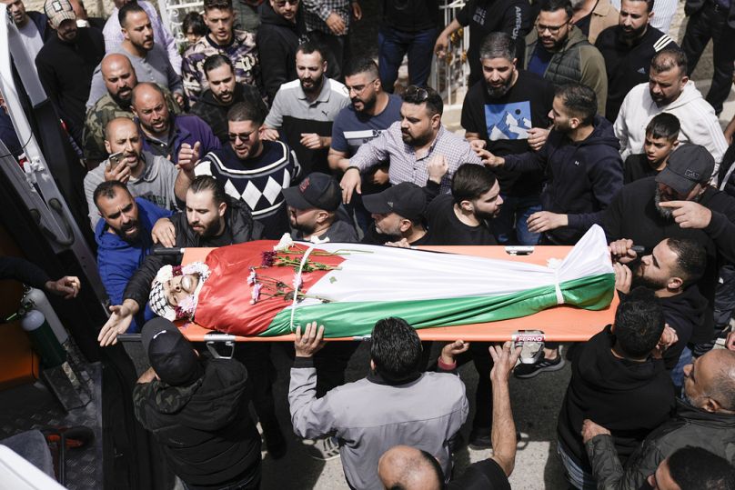 Palestinians gather next to the body of Omar Hamed during his funeral at the village of Beitin, near the West Bank city of Ramallah in the occupied West Bank, Sunday, April 14