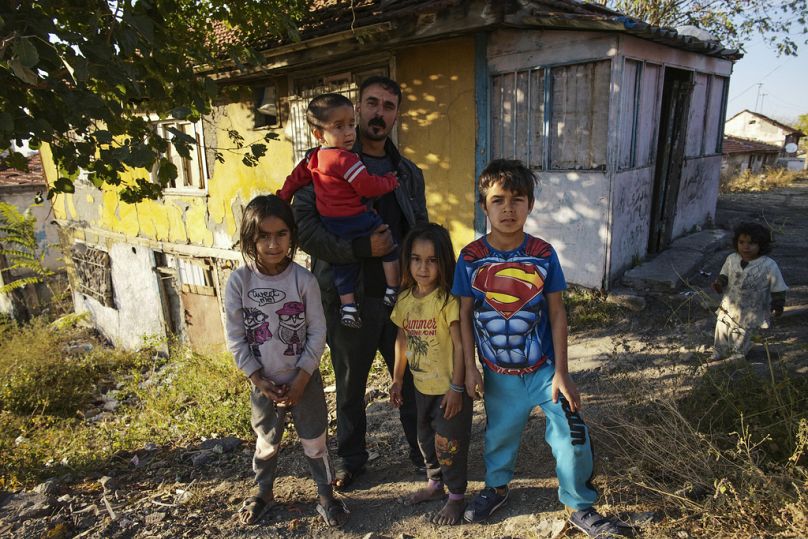Nidal Jumaa, a Syrian from Aleppo, poses with his children outside their house in a low-income neighbourhood in Ankara.