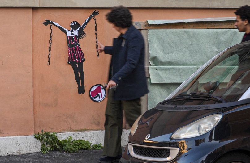 Passersby look at a mural painting depicting Italian antifascist activist Ilaria Salis in the act of breaking her chains near the Hungarian Embassy in Rome, Wednesday, Jan. 31
