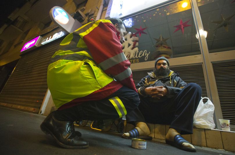 A volunteer from the Malta Order Bertand de Villermont to a homeless man in Boulogne-Billancourt, outside Paris, December 2014