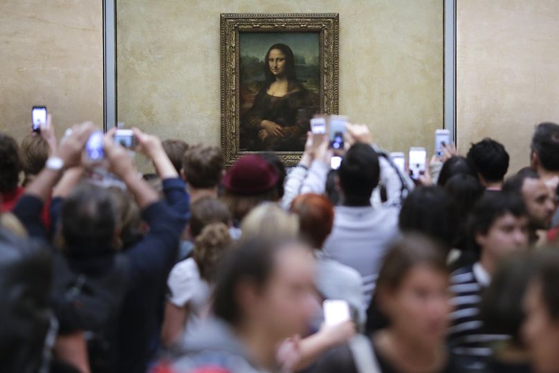 Visitors crowded in front of Leonardo da Vinci's painting 'Mona Lisa' at Musée du Louvre in Paris