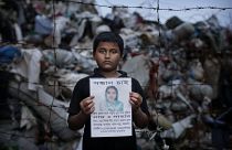 A family member holds a picture of a garment worker, victim of the 2013 Rana Plaza factory collapse