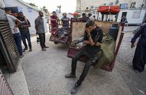 شاب فلسطيني يبكي فقدان أقاربه الذين قتلوا في قصف إسرائيلي في دير البلح