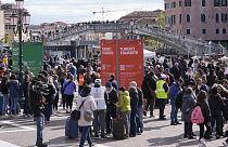 Stewards check tourists QR code access outside the main train station in Venice, Italy, 26 April 2024