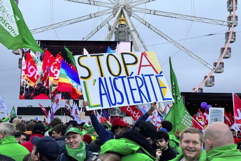 A protestor holds a sign which reads 'stop austerity' during a demonstration against austerity measures in Brussels, December 2023