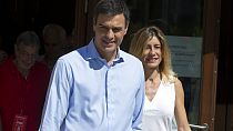 A journalist gives Spanish socialist leader Pedro Sanchez and his wife Begona Gomez leave a polling station during the national elections in Madrid, Spain, Sunday, June. 25