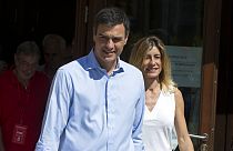 A journalist gives Spanish socialist leader Pedro Sanchez and his wife Begona Gomez leave a polling station during the national elections in Madrid, Spain, Sunday, June. 25