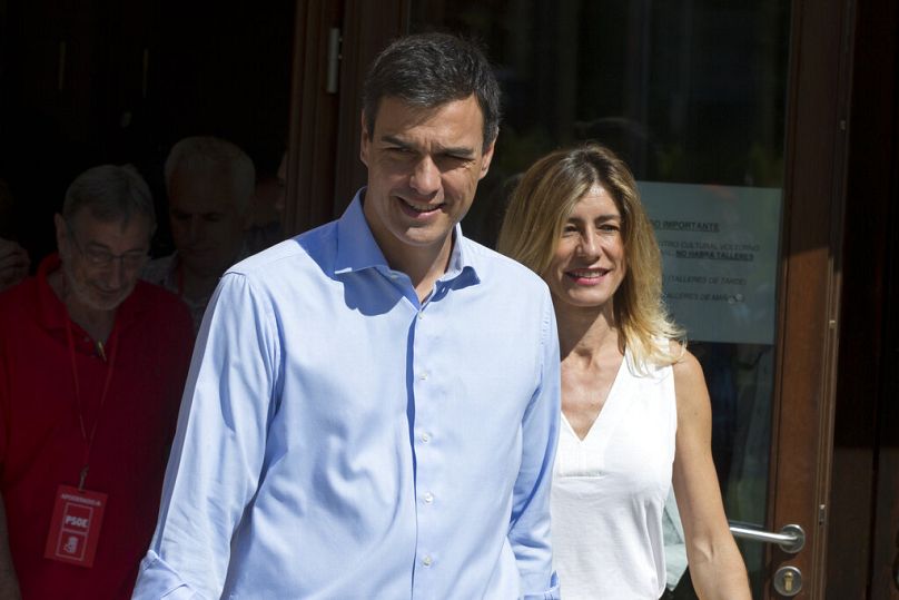 A journalist gives Spanish socialist leader Pedro Sanchez and his wife Begona Gomez leave a polling station during the national elections in Madrid, Spain, Sunday, June. 25, 2