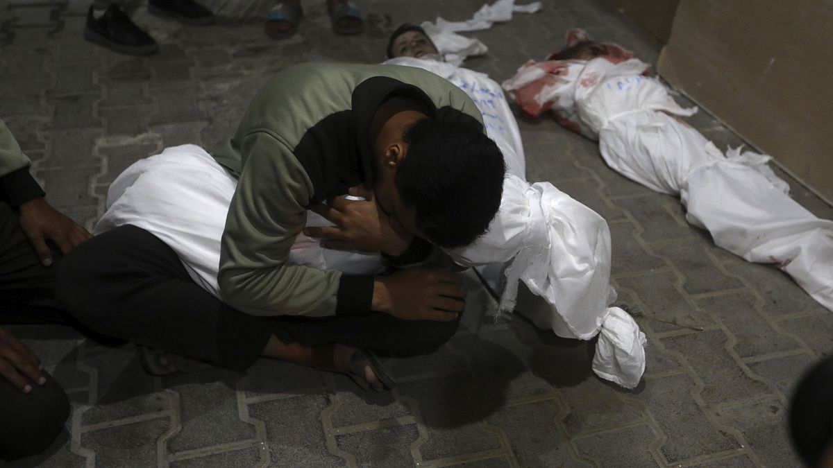 شاب فلسطيني يودع افراد عائلته بعد القصف الإسرائيلي على رفح، قطاع غزة. 