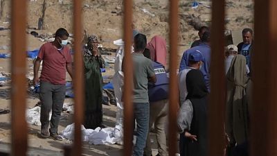 صورة مأخوذة من مقطع فيديو لفرق البحث وعائلات فلسطينية يبحثون في المقابر الجماعية