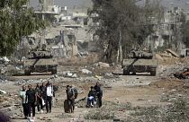 FILE - Palestinians flee from northern Gaza as Israeli tanks block the Salah al-Din road in the central Gaza Strip Friday, Nov. 24, 2023,