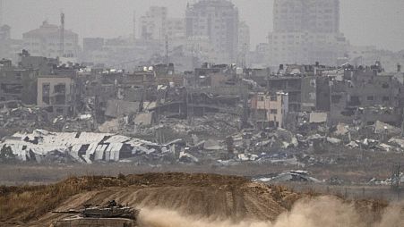 جنود إسرائيليون يتحركون فوق دبابة بالقرب من الحدود بين إسرائيل وغزة