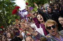 Pessoas com cravos vermelhos gritam "Fascismo nunca mais!" enquanto marcham pela Avenida da Liberdade, em Lisboa, para celebrar o 50º aniversário da Revolução dos Cravos Cr