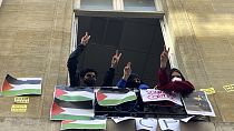 Sciences-Po üniversitesini engelleyen öğrenciler 26 Nisan 2024 Cuma günü Paris'te V işaretini yakıyorlar. Prestijli bir üniversitedeki öğrenciler Cuma günü Filistin yanlısı protestolara devam etti.