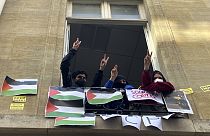 Студенты, блокирующие университет Sciences-Po, мигают табличкой V в пятницу, 26 апреля 2024 года, в Париже. В пятницу студенты престижного университета возобновили пропалестинские протесты.