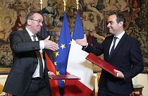 Ο Γάλλος υπουργός Άμυνας Σεμπαστιέν Λεκόρνου, δεξιά, και ο Γερμανός ομόλογός του Μπόρις Πιστόριους σφίγγουν τα χέρια μετά την υπογραφή συμφωνίας στο Παρίσι την Παρασκευή 26 Απριλίου 2024. 