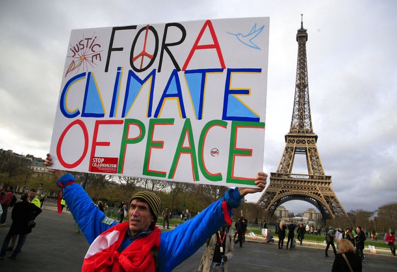 An activist hold a poster during a demonstration near the Eiffel Tower during the COP21 in Paris, December 2015