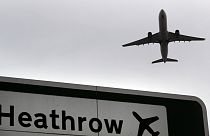 Trouble ahead? A plane takes off over a road sign near Heathrow Airport.