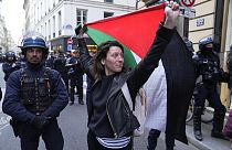 Eine Frau hält eine Palästina-Flagge in der Nähe der Universität Sciences-Po in Paris, Freitag, 26. April 2024.