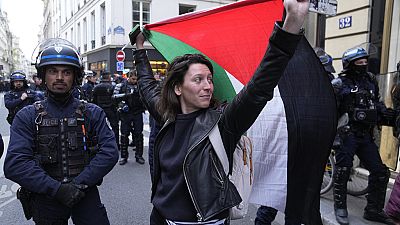 Eine Frau hält eine Palästina-Flagge in der Nähe der Universität Sciences-Po in Paris, Freitag, 26. April 2024.