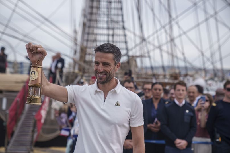 El waterpolista griego Ioannis Fountoulis lleva la llama olímpica hasta la embarcación Belem.