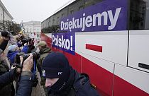 People cheer as a bus carrying Polish Prime Minister Donald Tusk and his ministers leave heading to the presidential palace in Warsaw, Poland (AP Photo/Czarek Sokolowski)