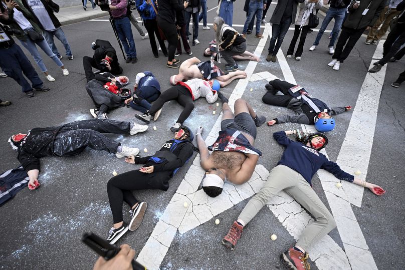Manifestantes deitam-se na rua durante um protesto pró-palestiniano contra a guerra entre Israel e o Hamas no jantar da Associação de Correspondentes da Casa Branca.